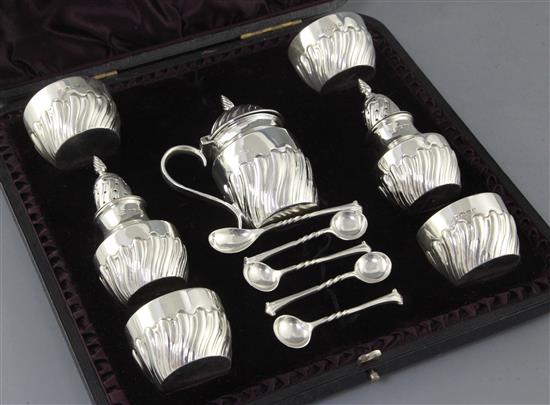 A cased Victorian repousse silver seven piece condiment set by James Deakin & Sons Ltd,